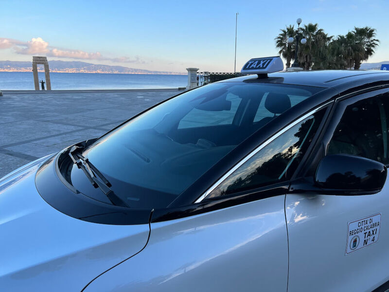 Taxi con licenza del Comune di Reggio Calabria sul lungomare Falcomatà, con vista sullo Stretto di Messina